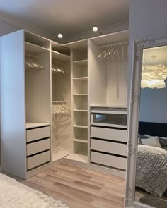 an empty bedroom with white closets and drawers