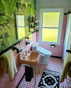 a bathroom with pink walls and black and white flooring