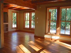 an empty living room with wood floors and lots of sunlight coming in through the windows