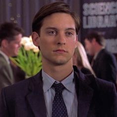 a young man in a suit and tie looking at the camera