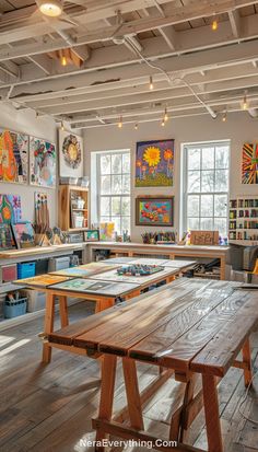 an art studio with wooden tables and paintings on the walls