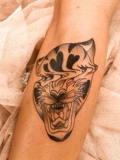 a tattoo on the leg of a woman with a tiger head and black lines around it