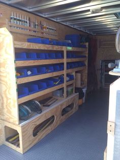 the inside of a storage area with blue bins and other items on shelves in it