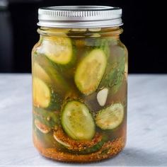 a jar filled with pickles sitting on top of a counter