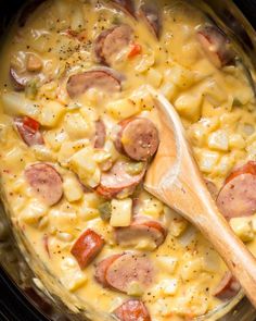 sausage and macaroni casserole in the crock pot with a wooden spoon