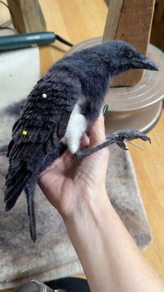 a person holding a stuffed bird in their hand