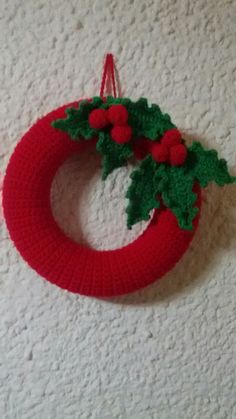 a knitted christmas wreath hanging on the wall