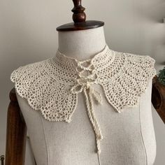 a white crochet collar on a mannequin