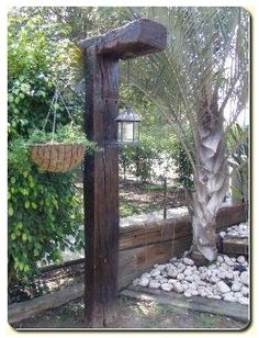 an outdoor area with rocks and trees in the foreground, along with a lantern hanging from a tree