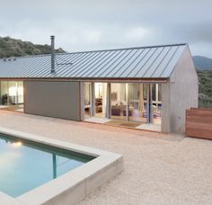 a house with a pool in front of it and a patio area next to it