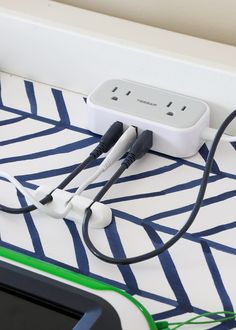 an electrical outlet plugged in to a charger on top of a bed sheet