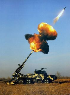 a black and white photo of a rocket being launched from a truck in the field