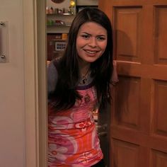 a woman standing in front of a wooden door