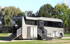 an rv parked on the side of a road with stairs leading up to it's door