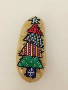 a painted rock with a christmas tree on it