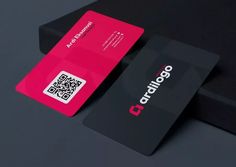 a black and pink business card sitting on top of a table