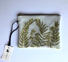 a white pouch with green leaves on it