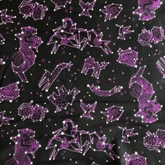 purple and black fabric with white stars and animals on the back in an abstract pattern