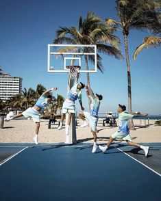 some people are playing basketball on a court with palm trees and the ocean in the background