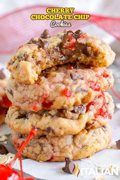 three cookies stacked on top of each other with chocolate chips and cherries in the middle