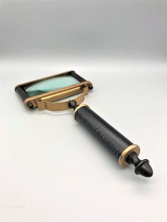 a magnifying glass sitting on top of a black and gold cased object