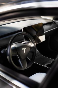 the interior of a modern car with black leather and chrome trims, including steering wheel