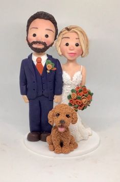 a wedding cake topper with a bride and groom standing next to a brown dog