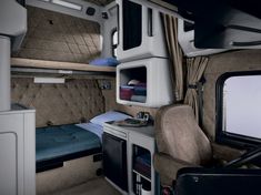 the interior of an rv with a bed and desk