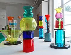 colorful glass vases sitting on top of a white table