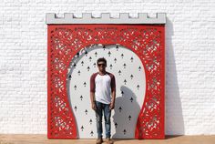 a man standing in front of a red and white wall