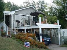 a car is parked in front of a house with an awning on the porch