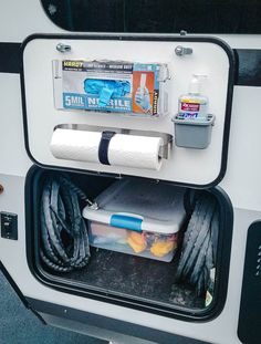 the inside of a camper with its door open and various items in the trunk