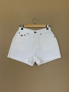 "High waisted 90's denim shorts. Made by Tommy Hilfiger in classic white denim wash with embroidered Tommy Hilfiger logo on back pocket. Shorts are in excellent clean condition with light naturally distressed character. Measurements (taken zipped or buttoned up and laid comfortably flat) inches x 2 for total circumference (inches) Tag Size 10 Tommy Hilfiger 100% Cotton Waist 27\" Hips 42\" Length 13.5\" Inseam 2.5\" Rise 11\" Bottom leg circumference 26\" All items are free of rips, tears, holes White Relaxed Fit Retro Bottoms, Retro White Shorts With Pockets, Retro White Short Bottoms, Classic White Bermuda Shorts, Vintage White Bottoms With Pockets, Vintage High Waist White Shorts, White Vintage Bottoms With Pockets, Vintage White Jean Shorts For Spring, Retro White Shorts For Spring