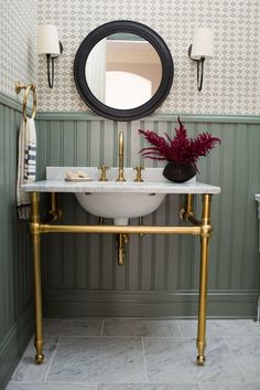 a white sink sitting under a mirror in a bathroom next to a wall mounted toilet