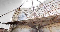 an industrial building with large metal tanks on the roof