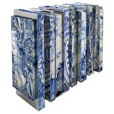 four blue and white boxes with designs on them, all lined up against one another