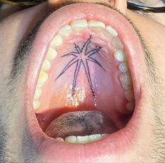 an open mouth with a palm tree tattoo on it