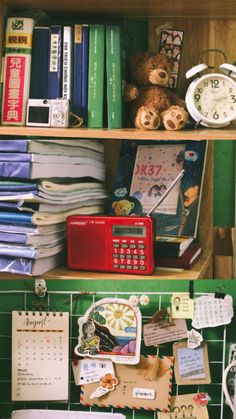 a shelf filled with lots of books next to a clock and other items on top of it