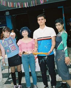 three people standing next to each other holding doughnuts