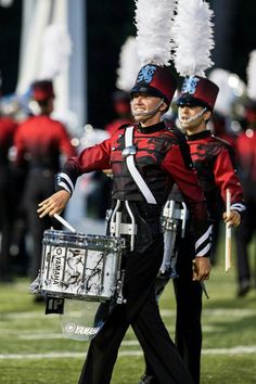 two men in red and black marching uniforms