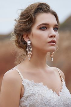 a woman in a white dress wearing earrings