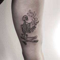 a skeleton sitting on top of a pair of skis with stars in the sky above it