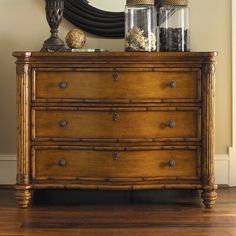 a dresser with jars and vases on top of it in front of a mirror