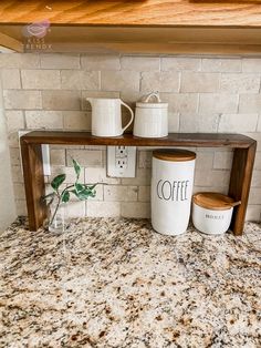 two coffee mugs are sitting on a shelf in front of a brick wall and counter