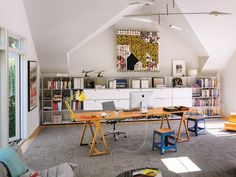 an office with multiple desks and bookshelves in the ceiling, along with two chairs