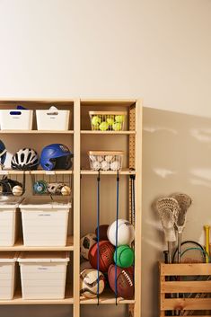 a wooden shelf filled with lots of different sports balls and baskets on top of it