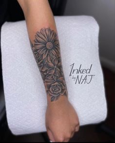 a woman's arm with flowers on it and the words inked by natt