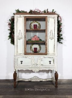 an old china cabinet is decorated with christmas wreaths