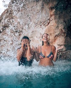 two women in the water with their hands on their faces