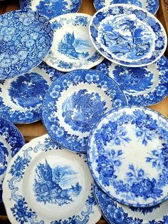 many blue and white plates stacked on top of each other